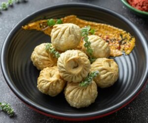 A bowl of fried dumplings served with garnishes and assorted dips, showcasing traditional cuisine.