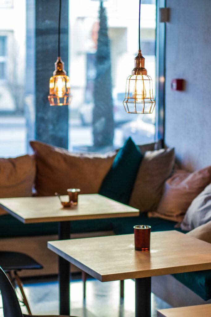 Warm and inviting cafe interior featuring modern pendant lighting and comfortable seating.